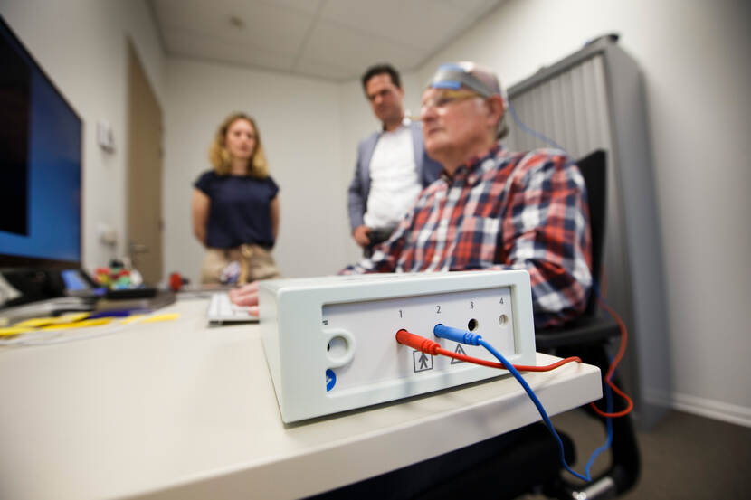 De deelnemer van het STIM-onderzoek ontvangt hersenstimulatie via twee electrodes op het hoofd tijdens het doen van een aantal computertaakjes.